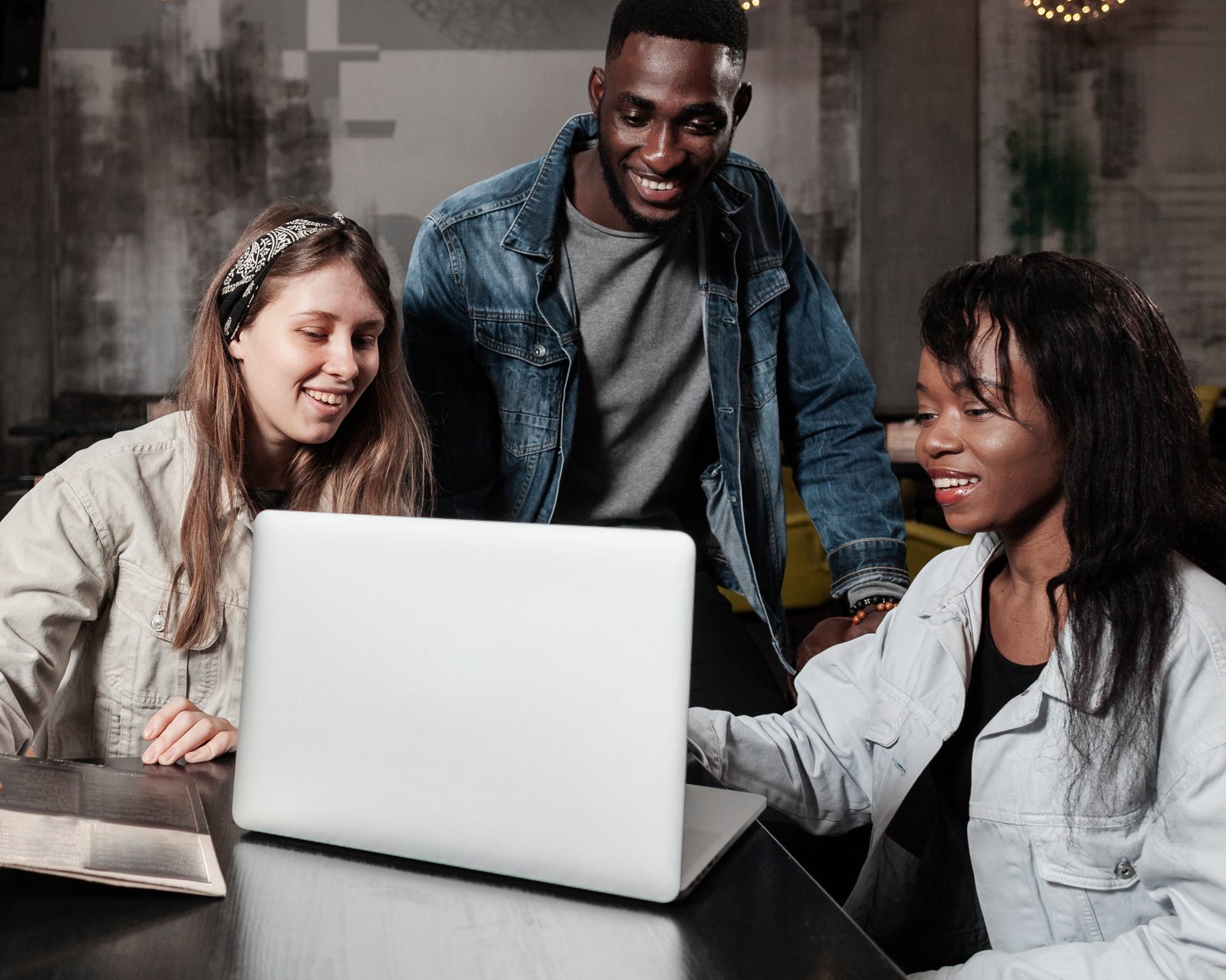 Happy friends looking at laptop indoors